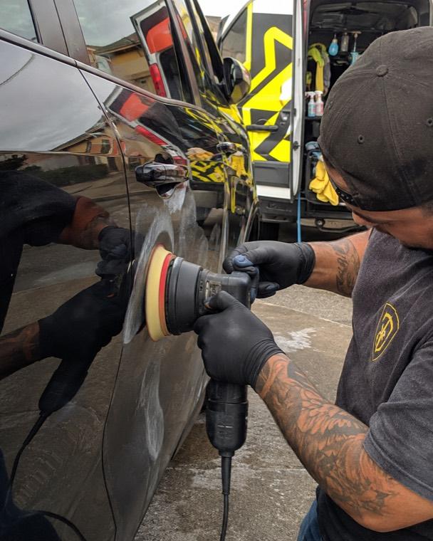 Detailer polishing a vehicle